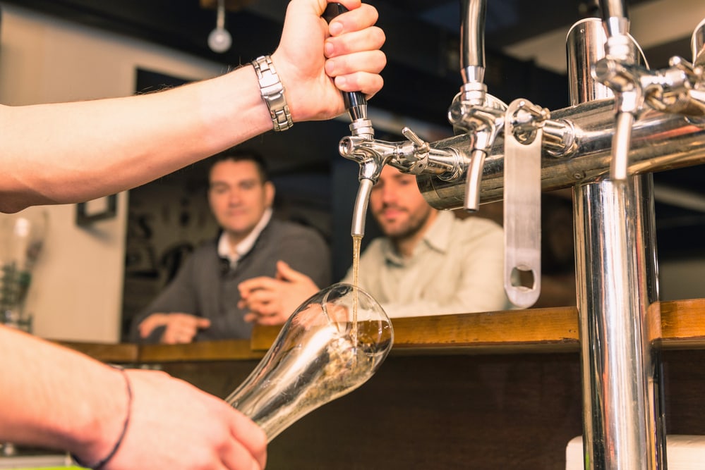 Bartender pouring beer from tap